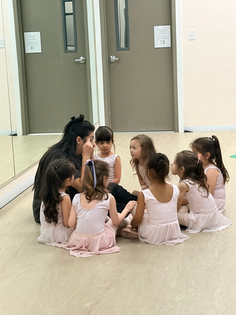 Young dancers gathered on the studio floor during class