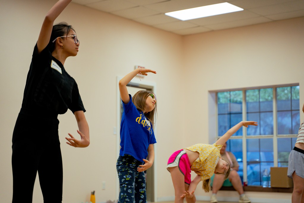 An instructor working through choreography with a young dancer