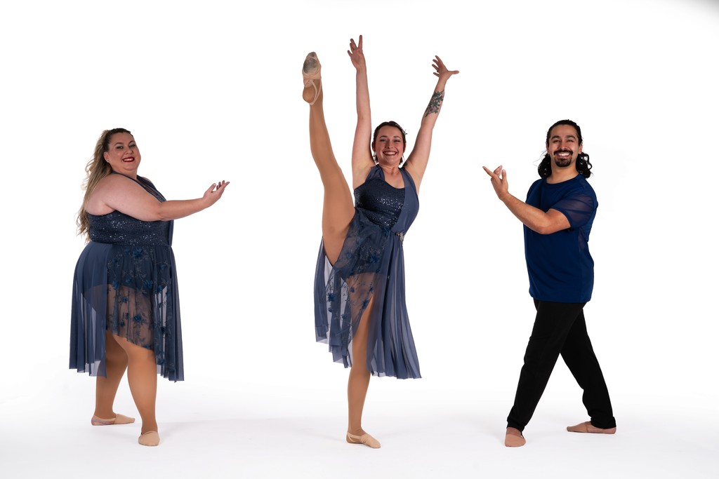 An adult B3 Dance performer mid-routine with arms extended